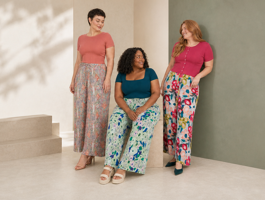 Three women styling paisley, mint botanical and large pink floral wide-leg pleated trousers.