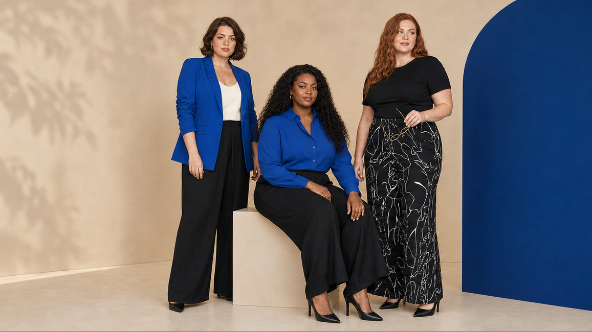 Three plus-size women in cobalt blue and black wide-leg workwear in a warm architectural studio