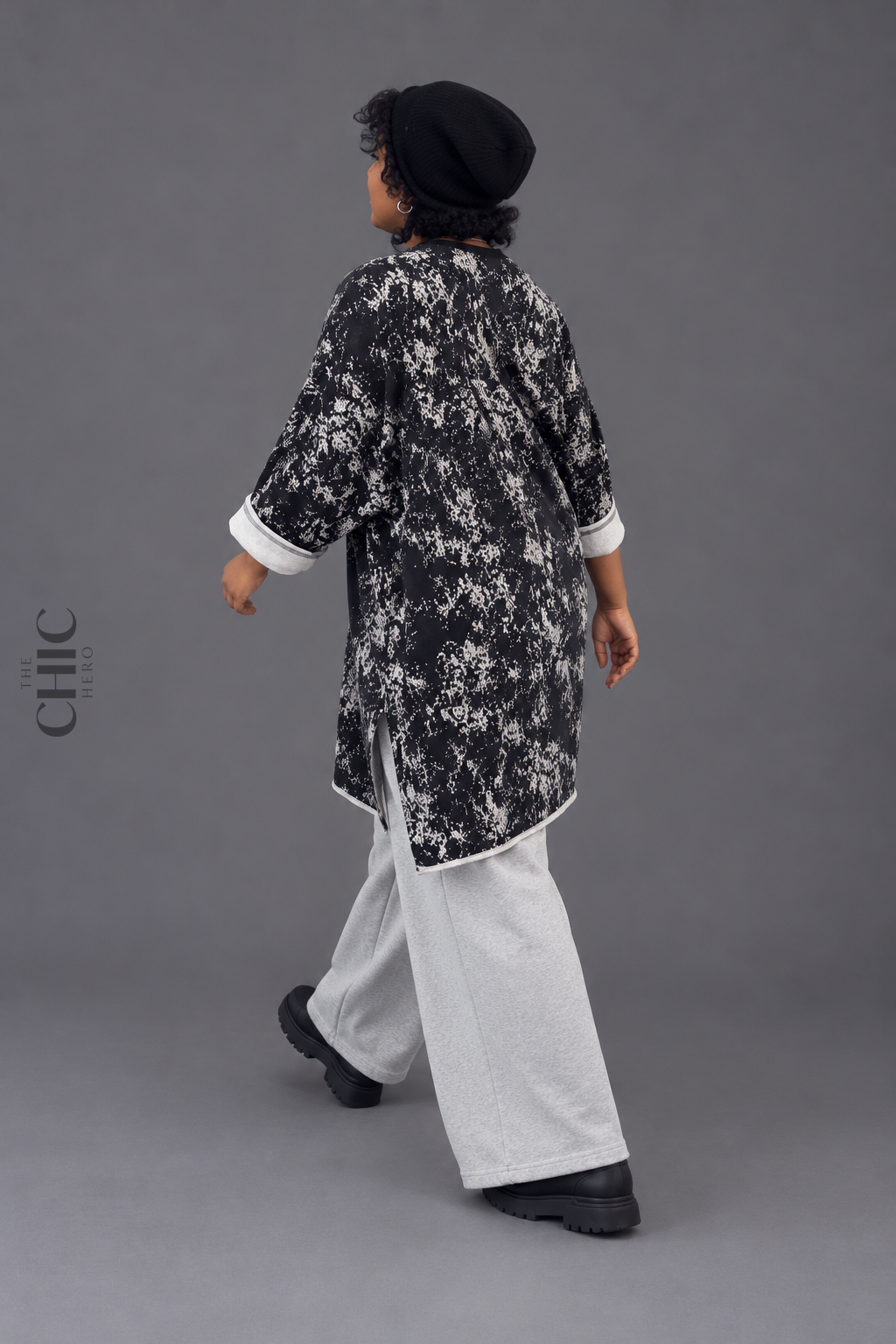 Back walking view of the oversized abstract print longline sweatshirt showing relaxed hip coverage and side slits