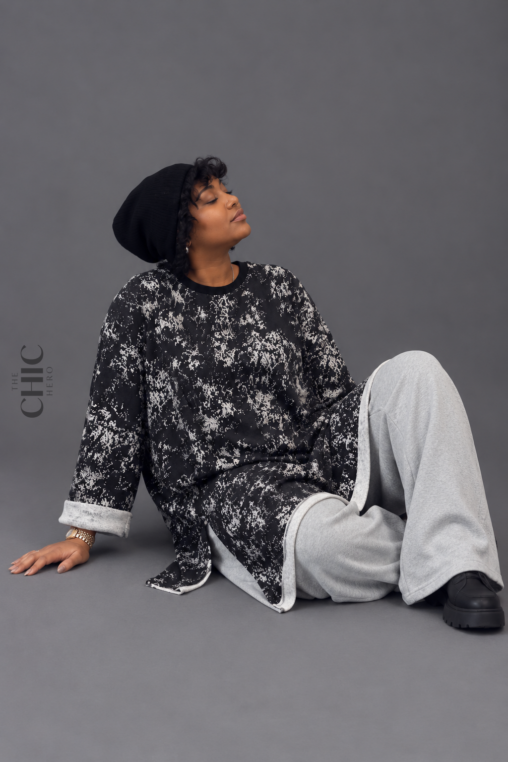 Seated styling of the plus size black and white longline sweatshirt with roomy sleeves and an easy loose fit