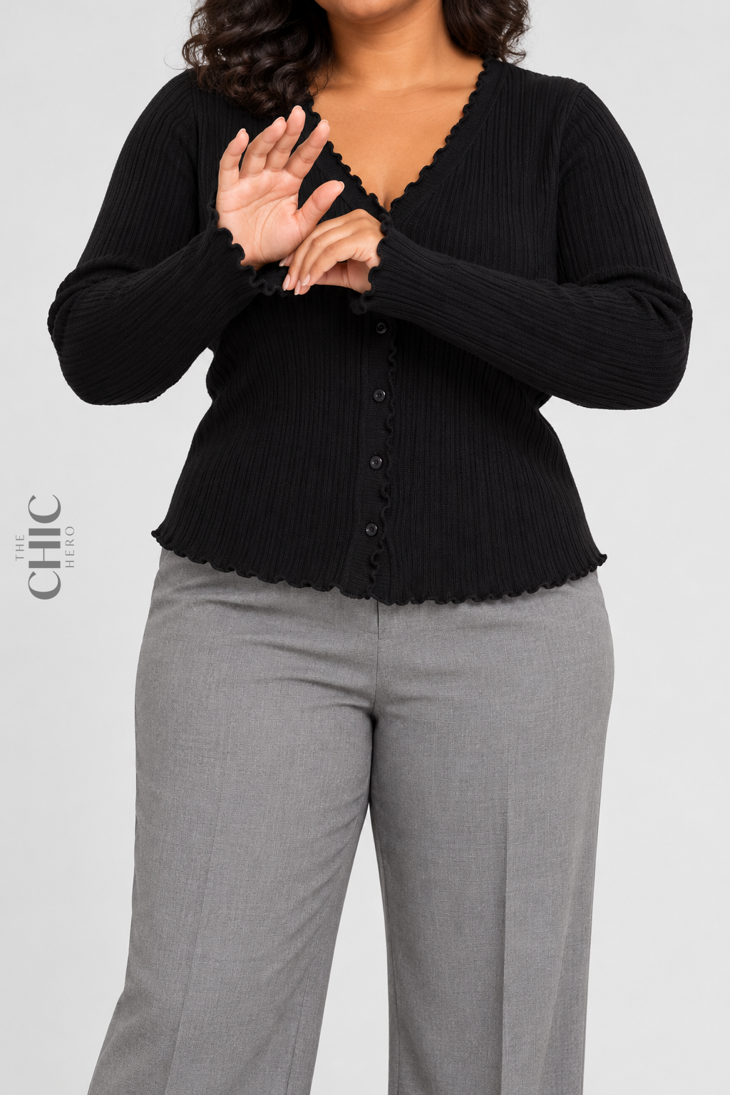 Black ribbed cardigan with ruffle cuffs shown on a faceless curvy model