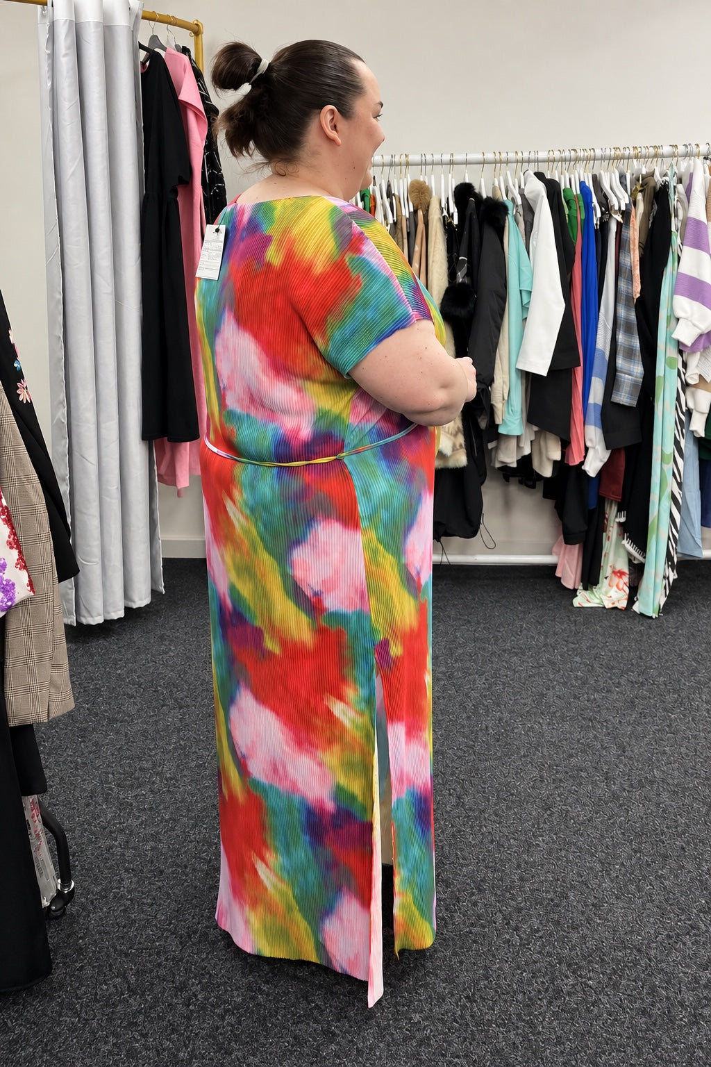 A model wearing a colourful pleated dress in The Chic Hero studio