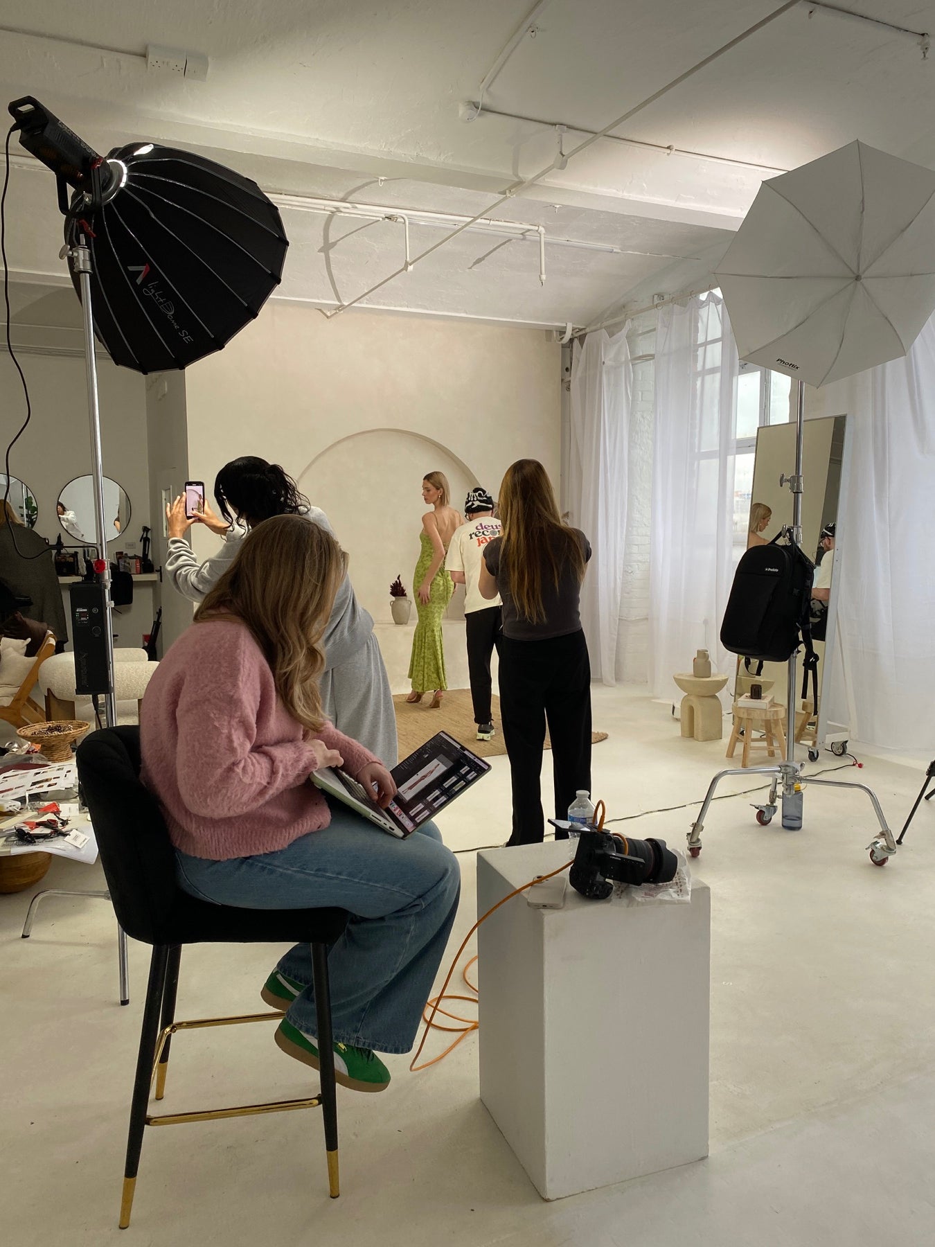 The Chic Hero team at a fashion photoshoot with a model in a green dress