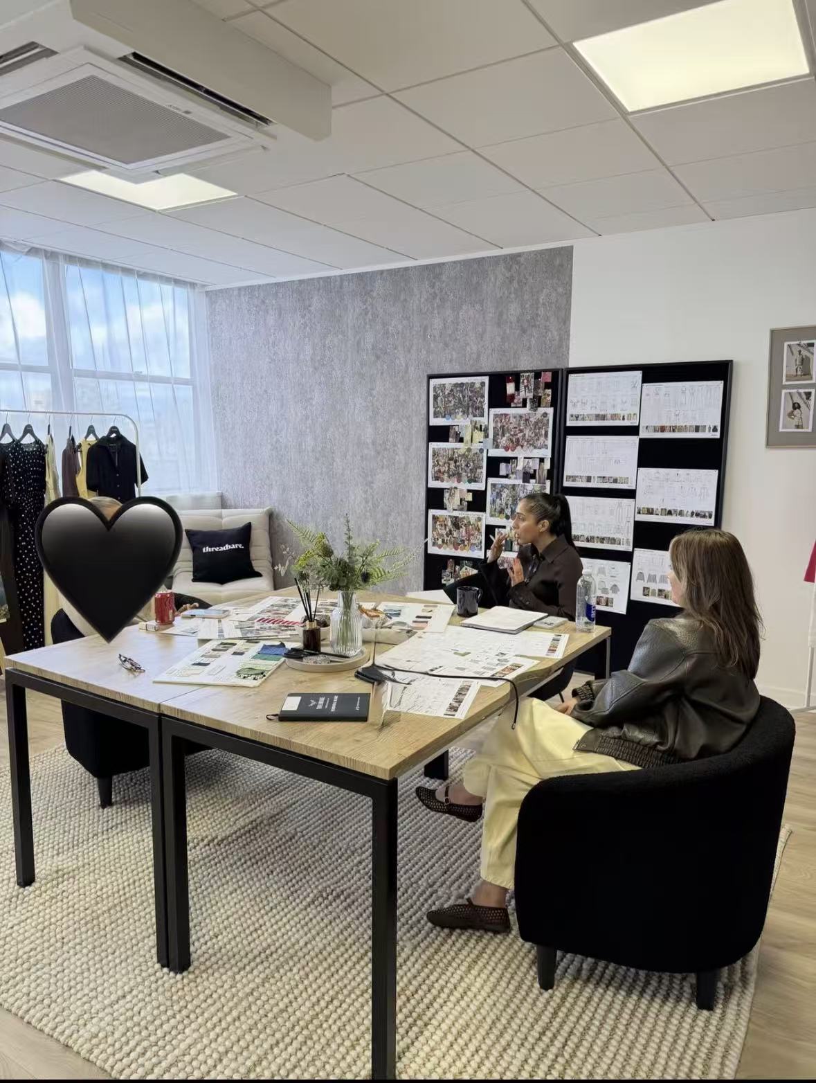 The Chic Hero team discussing designs around a table