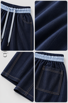 Denim blue trousers details showing the elastic waist, drawcord, pockets, fabric and contrast stitching
