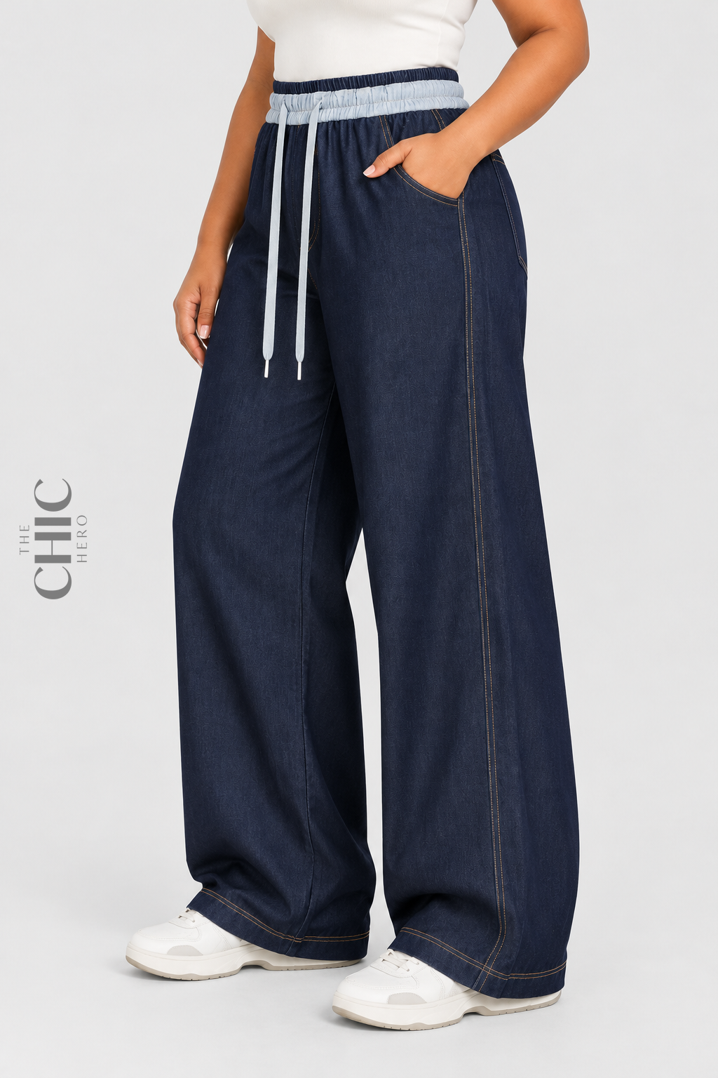 Denim blue wide-leg drawstring trousers side view showing the roomy leg and curved pocket
