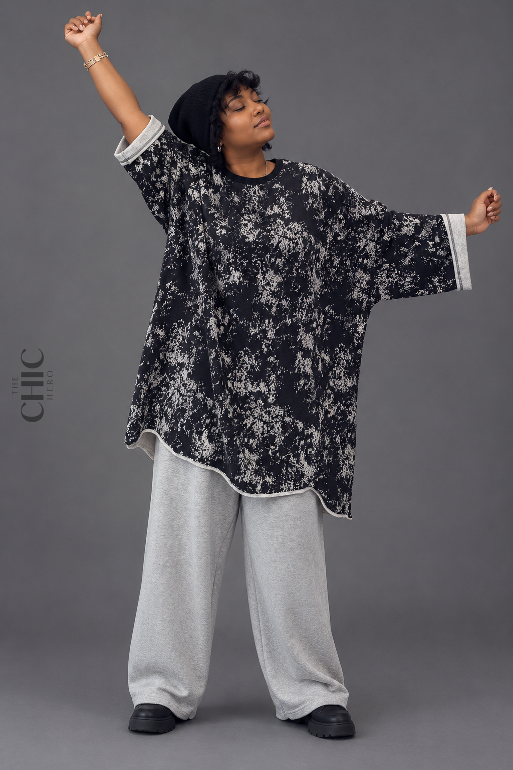 Plus size Black model wearing a black and white abstract print oversized longline sweatshirt with wide sleeves