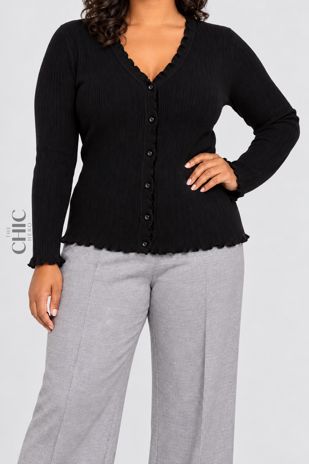 Black V-neck ruffle-trim cardigan styled with grey trousers