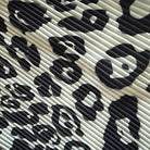 A close-up of a black and off-white leopard print fabric with a textured, ribbed surface.