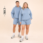 Male and female models wearing the ChicHero blue heavyweight hoodie and shorts