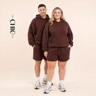 Male and female models wearing the ChicHero brown heavyweight hoodie and shorts